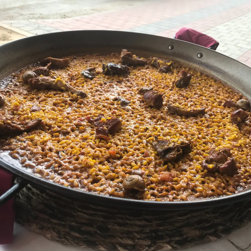 Arroz con conejo y caracoles en paellera, vista cenital