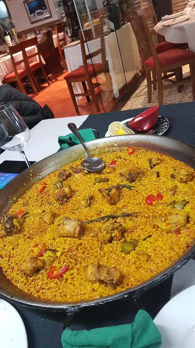 Paellera de arroz servida en una mesa de la sala