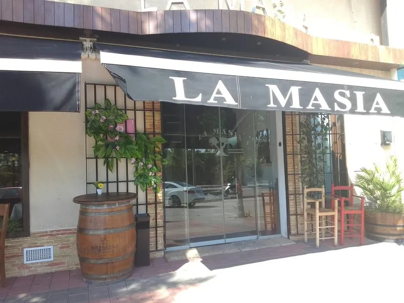 Fachada de La Masía con el toldo y el rótulo del restaurante